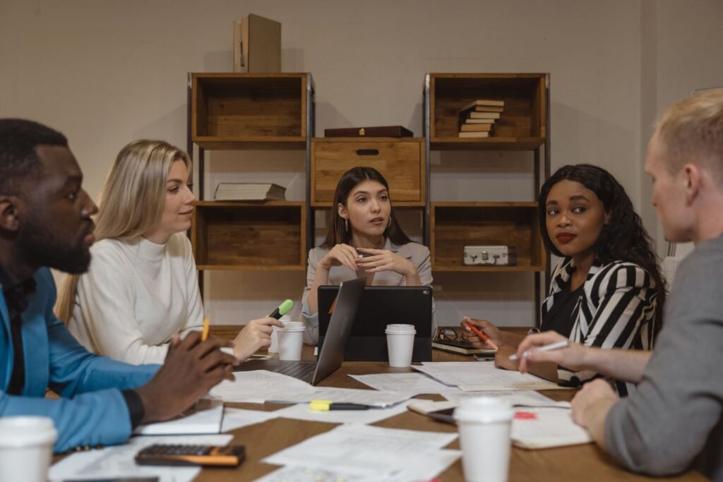 Equipe multicultural discutindo estratégia comercial e precificação em escritório moderno