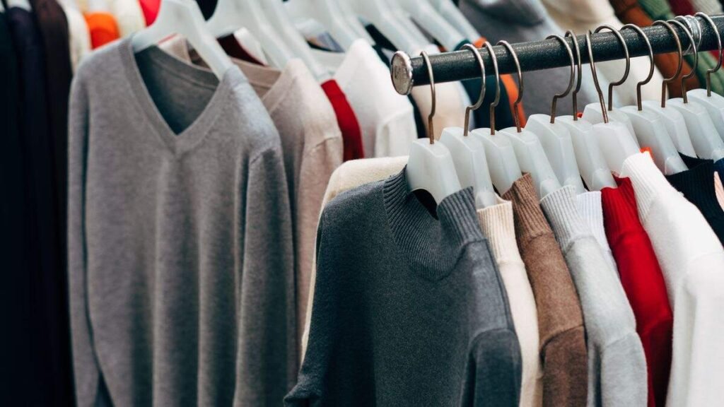 Roupas coloridas penduradas em cabides em uma arara de loja